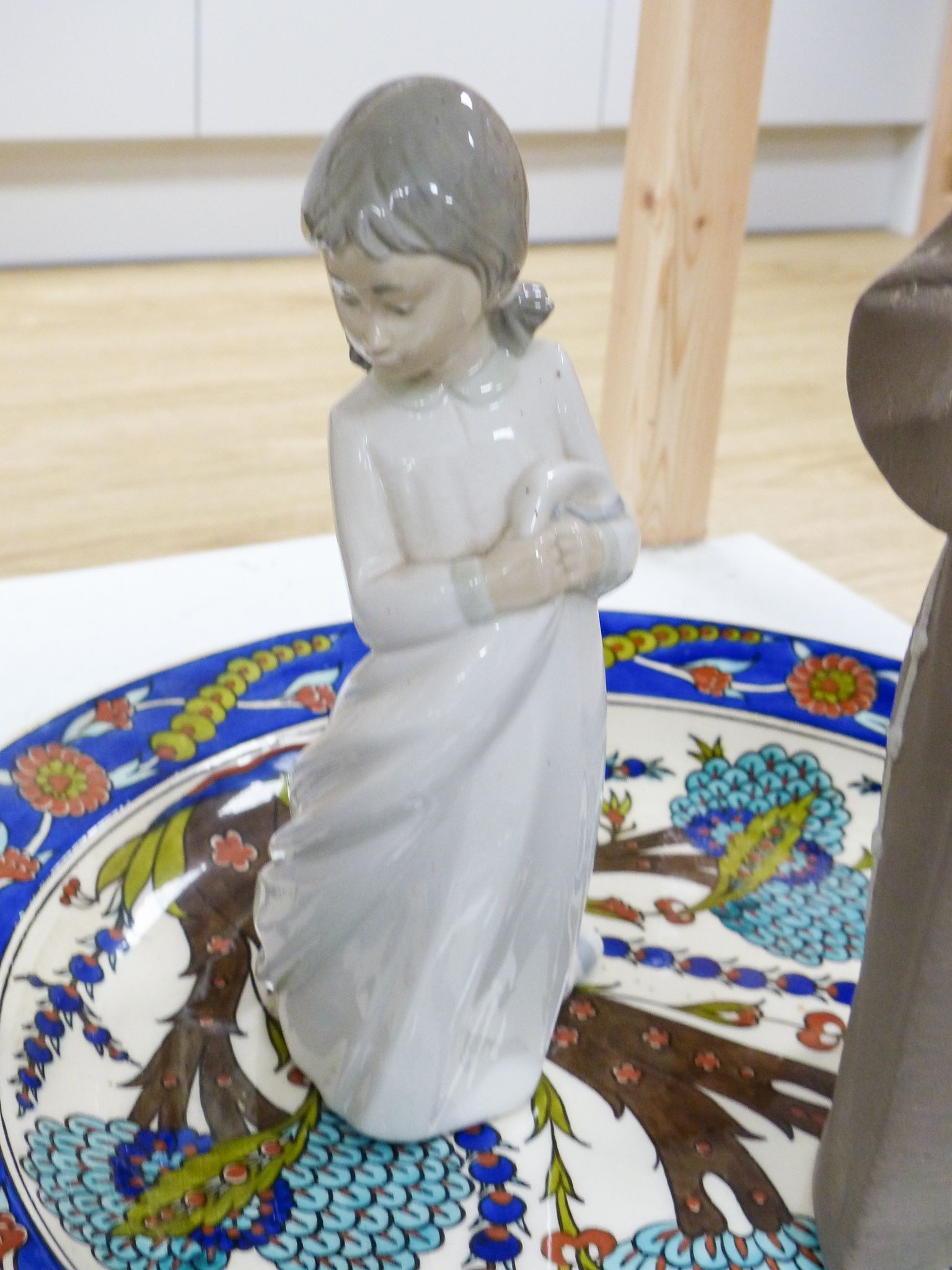 A Lladro figure of a monk, a Nao figure of a girl and an Isnik style dish (3)